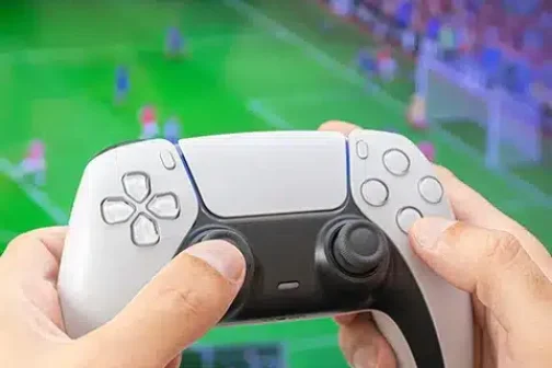 Man holding game controller playing football game.